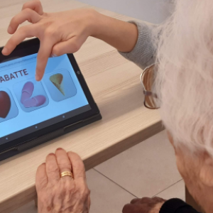 Intellica, software che potenzia capacità cognitive, relazionali e emotive. Persona che tocca lo schermo di un tablet.