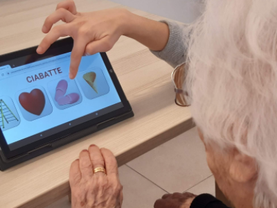 Intellica, software che potenzia capacità cognitive, relazionali e emotive. Persona che tocca lo schermo di un tablet.